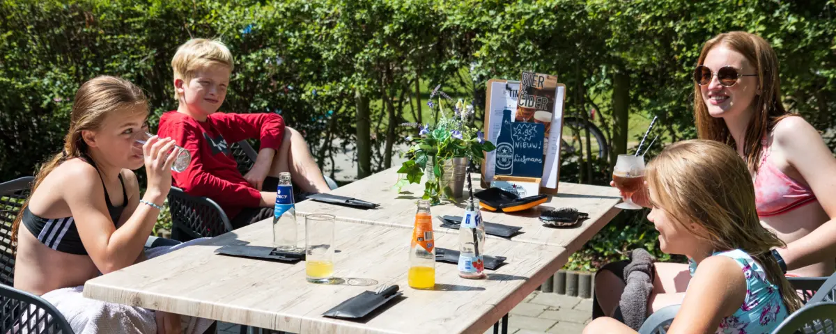 Kinderen op het terras van de brasserie op Camping de Vossenburcht in Overijssel